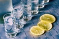 Vodka shot glass and lemon on blue surface Royalty Free Stock Photo