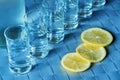 Vodka shot glass and lemon on blue surface Royalty Free Stock Photo