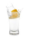 Vodka splashing out of shot glass with lemon on white background Royalty Free Stock Photo