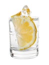 Vodka splashing out of shot glass with lemon on white background Royalty Free Stock Photo