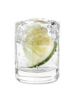 Vodka splashing out of shot glass with lime on white background Royalty Free Stock Photo