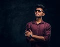 Vogue, fashion, style. Handsome young Indian guy wearing a stylish shirt and sunglasses posing with crossed arms. Royalty Free Stock Photo