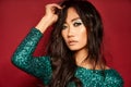 Vogue style close-up portrait of beautiful asian woman over red studio background Royalty Free Stock Photo