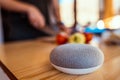 Voice controlled smart speaker in a interior kitchen. Man cutting vegetables in background. Royalty Free Stock Photo