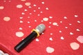 Voices of love as represented by a microphone and heart-shaped paper cuts