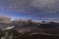 Volcanic ash coming out from the crater of the mountain and active volcano Bromo at night