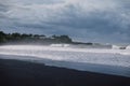 Volcanic black sandy beach with ocean waves in Bali. Beach and dark sky Royalty Free Stock Photo