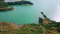Volcanic island lagoon drone view. Rippling turquoise ocean washing rocky coast.