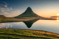 Volcanic Kirkjufell mountain with lake reflection and traveler man standing during sunrise at Iceland Royalty Free Stock Photo