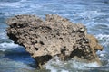 Volcanic rock jetting out of the water surrounded by crashing waves, Kaena Point, Oahu, Hawaii Royalty Free Stock Photo