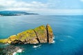 Volcanic rock and lonely sailing boat in waters of Atlantic Ocean Royalty Free Stock Photo