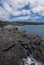 Volcanic rock outcrop at ocean shore Royalty Free Stock Photo