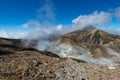 Volcanic vents with smoke and mountains with blue sky, sulphur and ash. Murodo, Japan alps Royalty Free Stock Photo