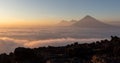 Volcano above sea of clouds at beautiful orange sunset seen from pacaya. Royalty Free Stock Photo