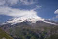 Volcano Elbrus, its peaks are slightly shrouded in clouds in sunny weather. Landscape view in the south-east of mount Royalty Free Stock Photo
