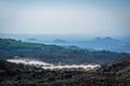 Volcano Etna view with tourists on their cars and lava stones all around in the mist