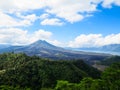 Volcano mountain view with lake, lush green forest, blue sky and