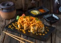 VOLCANO sushi roll served in a cutting board isolated on wooden background side view of sushi roll