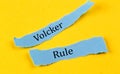 VOLCKER RULE text on a blue pieces of paper on yellow background, business concept