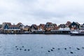 VOLENDAM, NETHERLANDS - December 24, 2019: Dutch harbor with city views, boats, Christmas decorations and ducks. Winter evening in