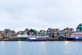 VOLENDAM, NETHERLANDS - December 24, 2019: Dutch harbor with city views, boats, Christmas decorations. Winter evening in