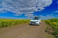 Volgograd region. Russia. August 10, 2020. White car with a cargo box on the roof on a village road among endless fields Royalty Free Stock Photo