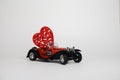 Volgograd, Russia-January 17, 2021. A small red retro bugatti car carries a heart. The Concept Of Valentine`s Day