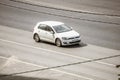 Volkswagen Golf Mk7 is seventh generation of the famous german hatchback. Aerial front side view of white car in motion