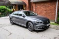 Volkswagen trade wind of gray color. Business sedan parked near a building on the street.