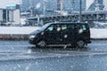 Volkswagen Transporter T5 car drives in winter snowfall in city. Risk on snow or ice skidding concept