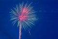 A volley of festive multi-colored fireworks against the blue sky close-up.