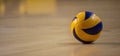 Volleyball ball on blurred wooden parquet background. Banner, space for text, close up view with details.