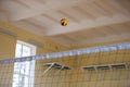 A volleyball ball flies over the net.