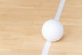 Volleyball ball on hardwood court floor with white line