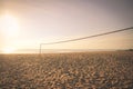 Volleyball net on empty beach sand in sunset or sunrise times Royalty Free Stock Photo