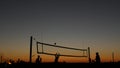 Volleyball net silhouette on beach court at sunset, players on California coast. Royalty Free Stock Photo