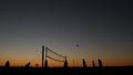 Volleyball net silhouette on beach court at sunset, players on California coast. Royalty Free Stock Photo