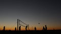 Volleyball net silhouette on beach court at sunset, players on California coast. Royalty Free Stock Photo