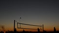Volleyball net silhouette on beach court at sunset, players on California coast. Royalty Free Stock Photo