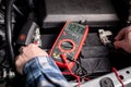 Master Mechanic tests the voltage of a truck battery using a voltage meter Royalty Free Stock Photo