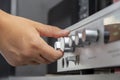 The volume knob on the amplifier turns the female hand, close-up, selective focus, top view. Royalty Free Stock Photo