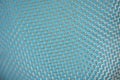 Volumetric fragment of weaving dirty metal mesh on a blue background. Rusty worn cells. Shallow depth of field Royalty Free Stock Photo