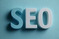 Volumetric letters forming the acronym seo, for search engine optimization, resting on blue background Royalty Free Stock Photo