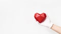 Volumetric paper heart in hand with white textile glove on white background Royalty Free Stock Photo