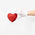 Volumetric paper heart in hand with white textile glove on white background Royalty Free Stock Photo