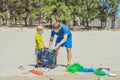 Volunteer blue face mask forest sand beach. Son helps father hold black bag for pick up garbage. Problem spilled rubbish