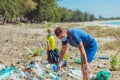 Volunteer blue face mask forest sand beach. Son helps father hold black bag for pick up garbage. Problem spilled rubbish