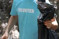 Volunteer in blue t-shirt holding garbage bag, ecology man cleaning and picking up trash to reduce land pollution environmental Royalty Free Stock Photo