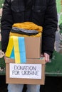 Volunteer carrying boxes with Humanitarian aid for Ukrainian refugees in street