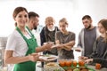 Volunteer with colleague giving food to poor people Royalty Free Stock Photo